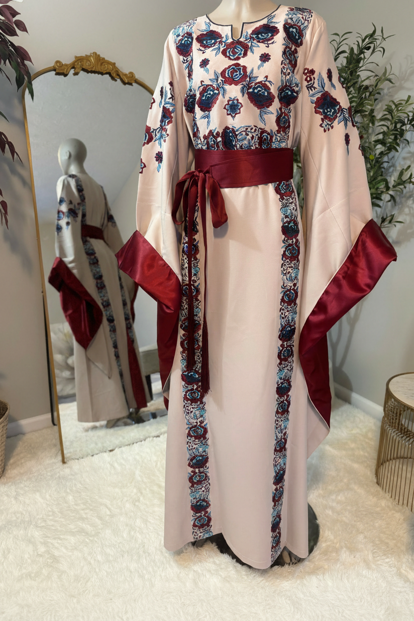Beige -colored fabric thobe with blue embroidery.