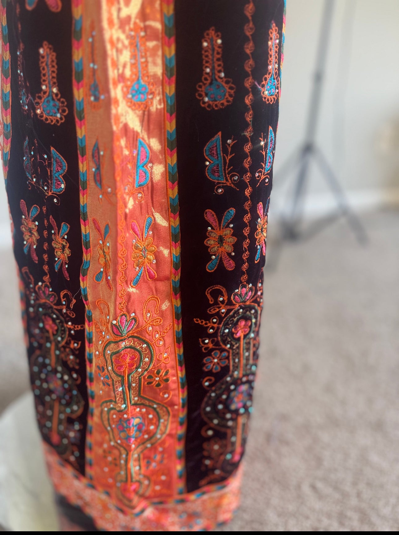 Cream thobe with burgundy velvet and orange satin accents.