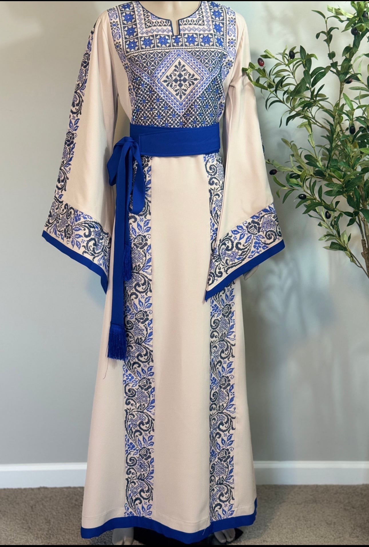 Cream thobe with royal blue embroidery.