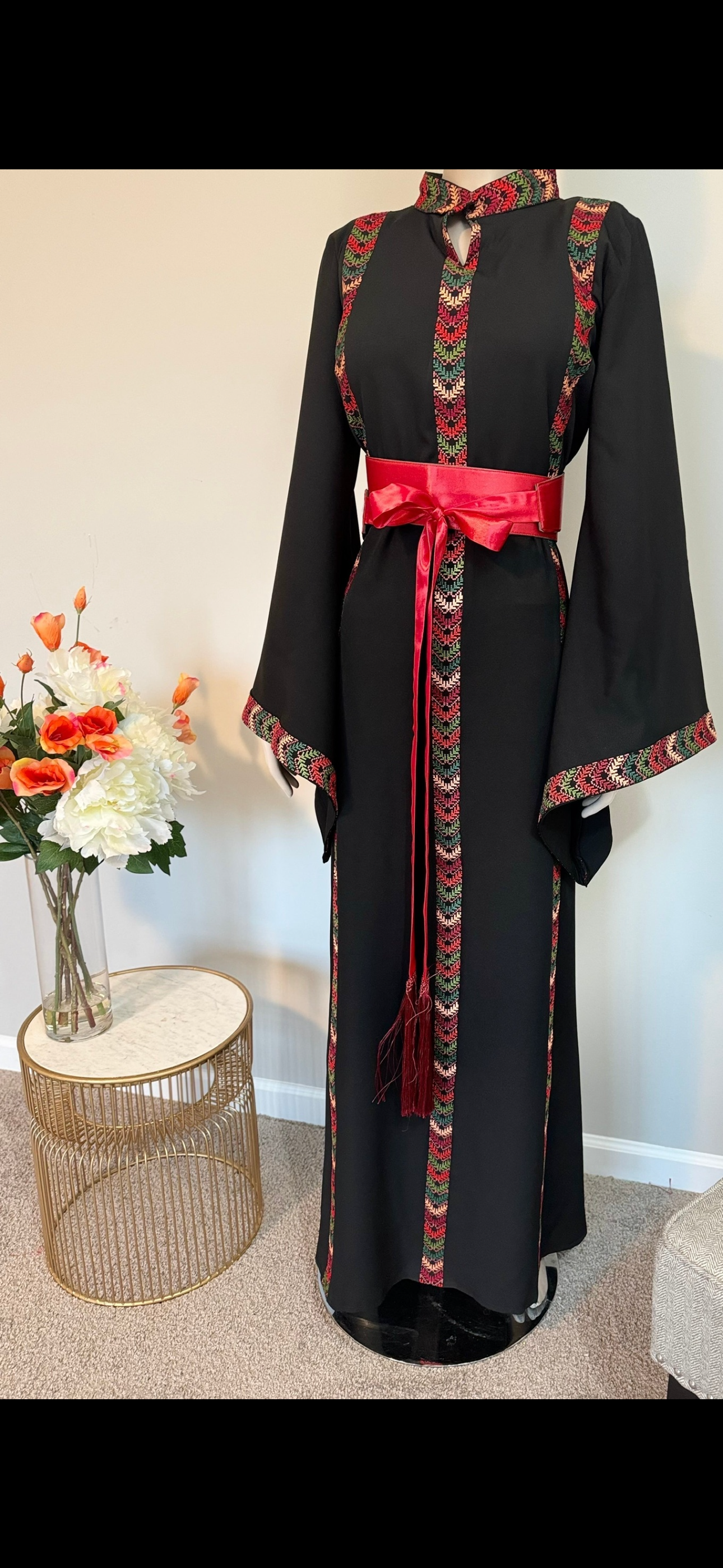 Black dress with embroidery and satin belt.