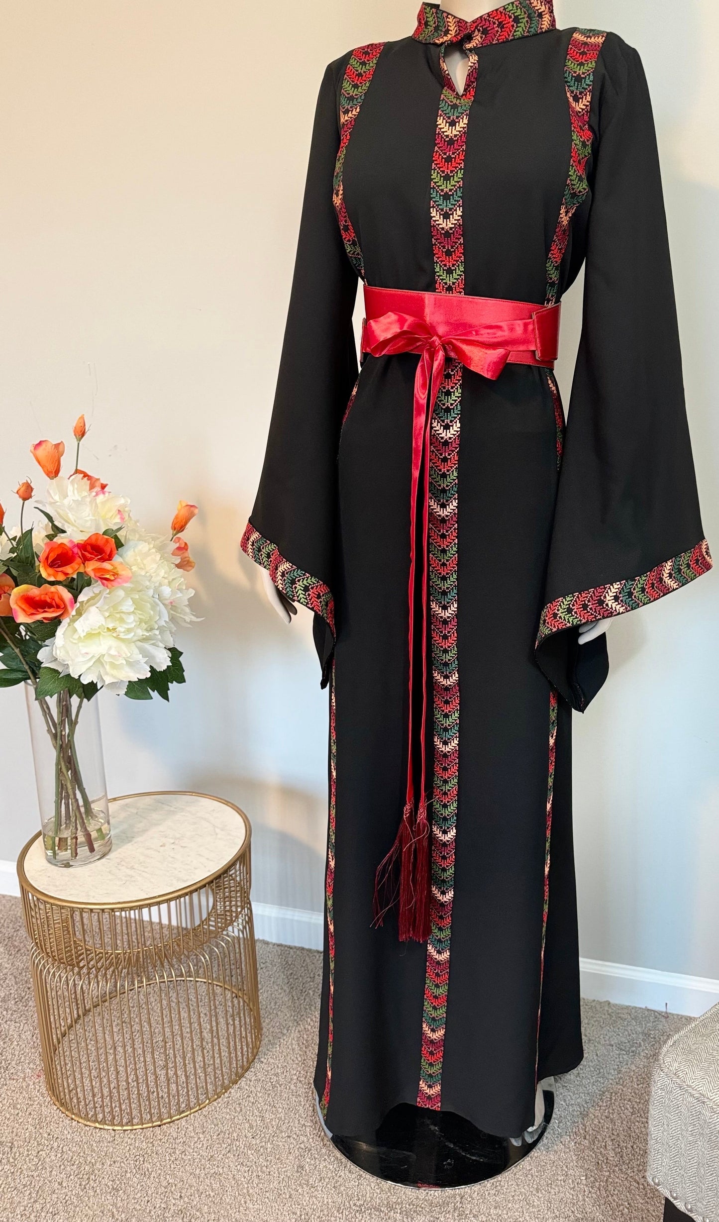 Black dress with embroidery and satin belt.