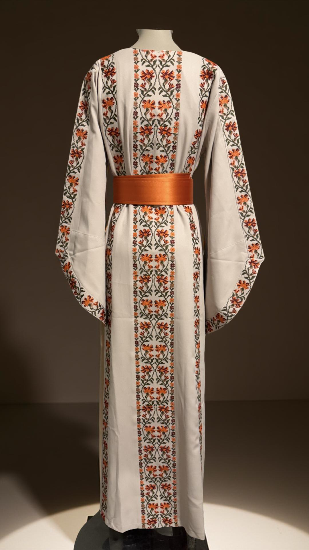 A beautiful beige and orangedress with fashionable sleeves.