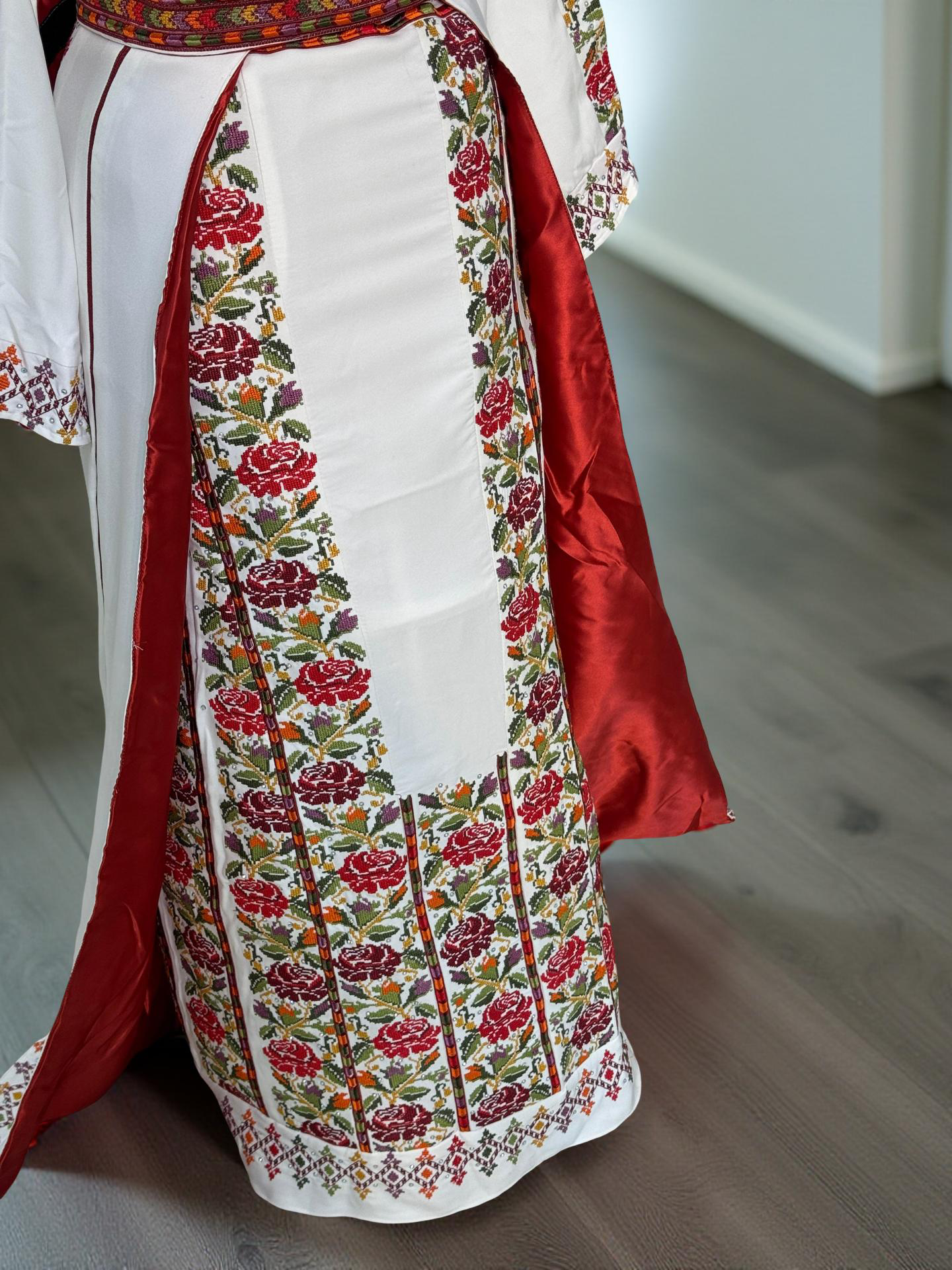 White thobe with colorful flowers and an overskirt.