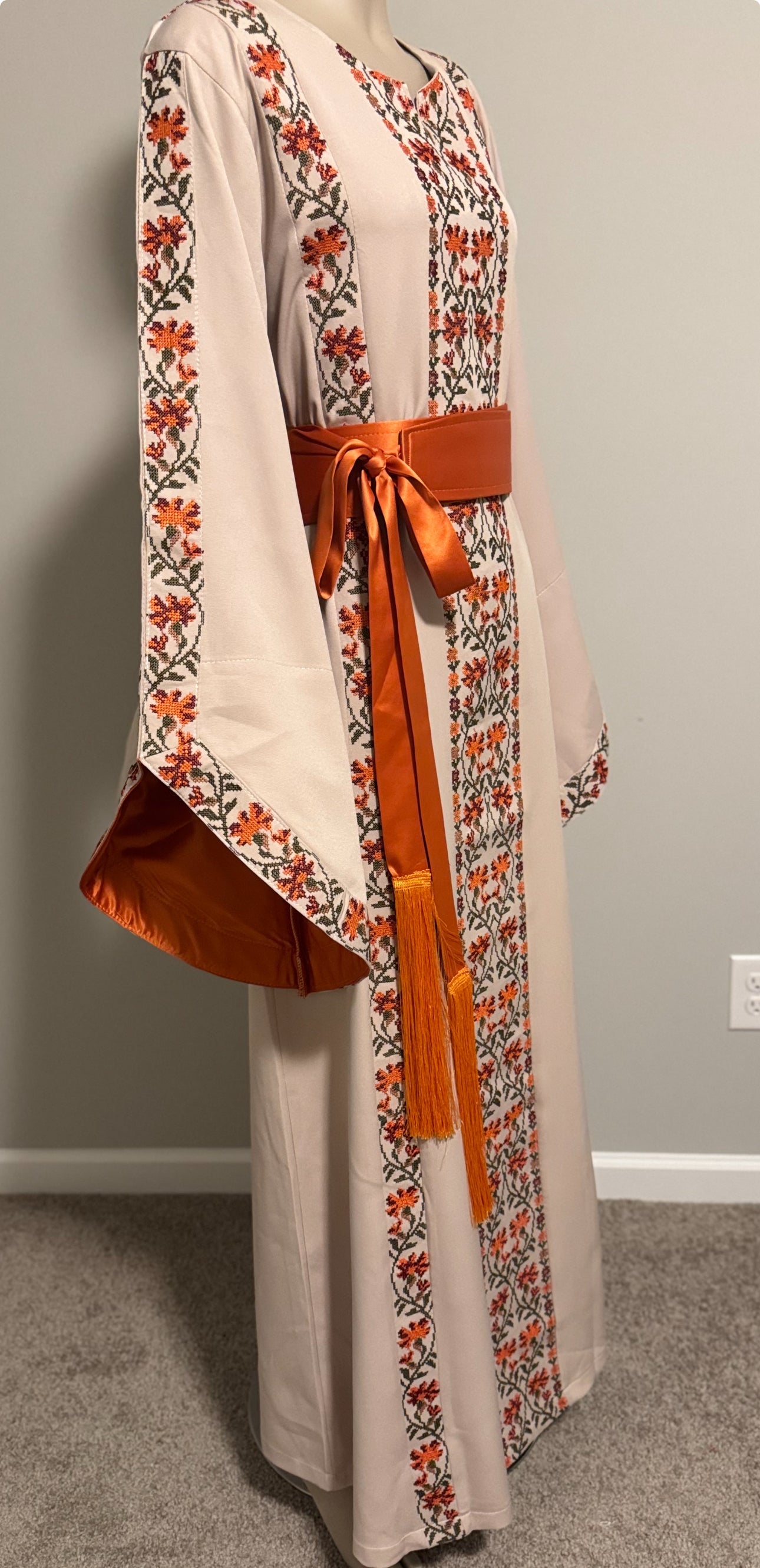 A beautiful beige and orangedress with fashionable sleeves.