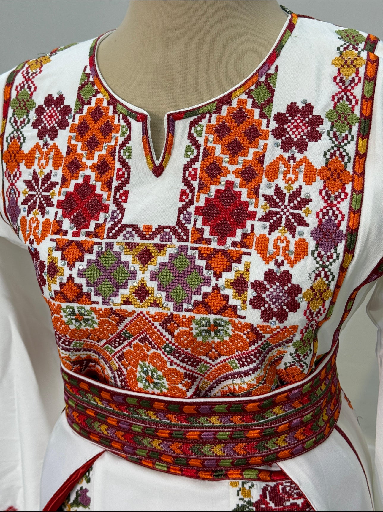 White thobe with colorful flowers and an overskirt.