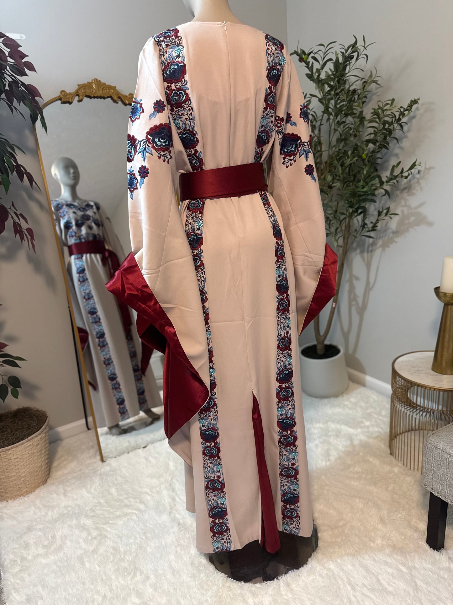 Beige -colored fabric thobe with blue embroidery.